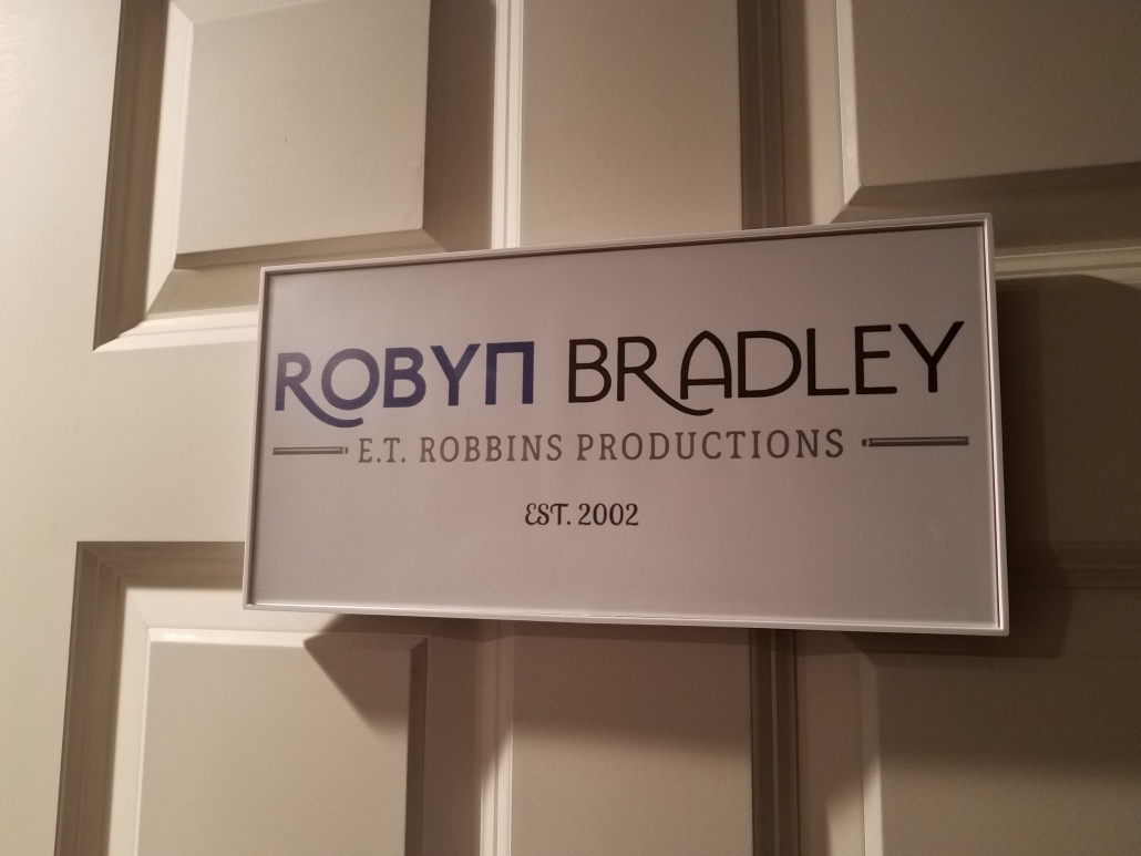 Picture of a sign on a door that says "Robyn Bradley. E.T. Robbins Productions. Est. 2002."
